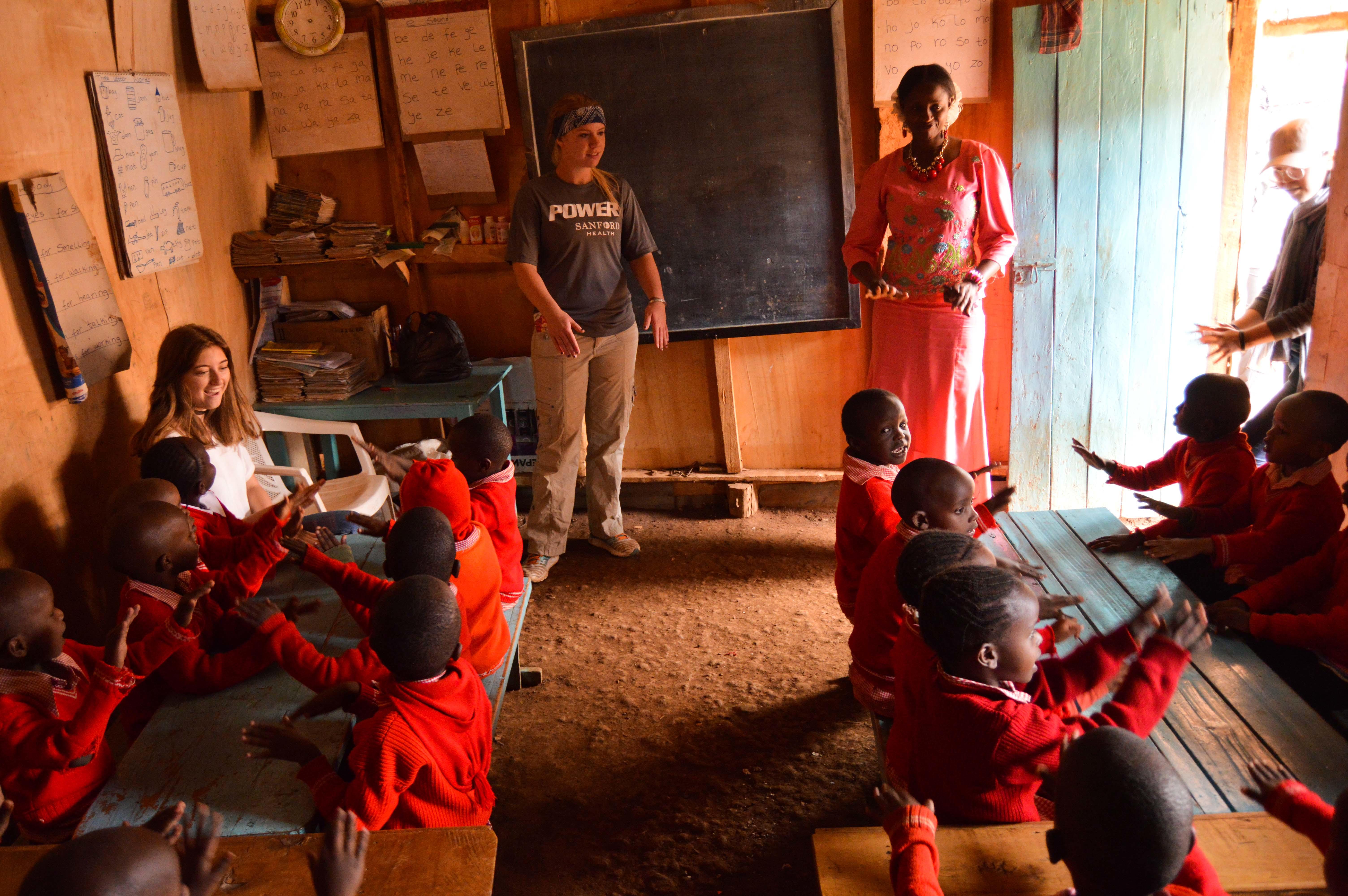 A Teaching volunteer participates in a class in Kenya at a local primary school. A Teaching volunteer supports a local teacher in a classroom in Kenya.